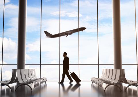 Man walking through airport with plane in background